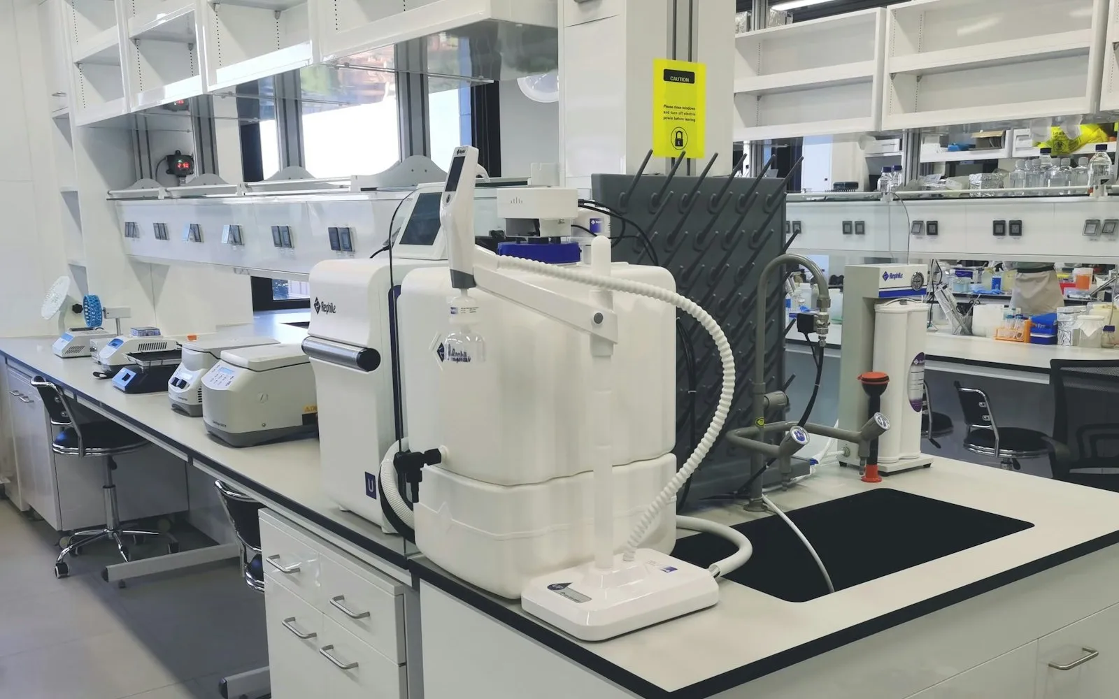 Vista wide di un laboratorio scientifico moderno con banchi multipli e strumentazione professionale